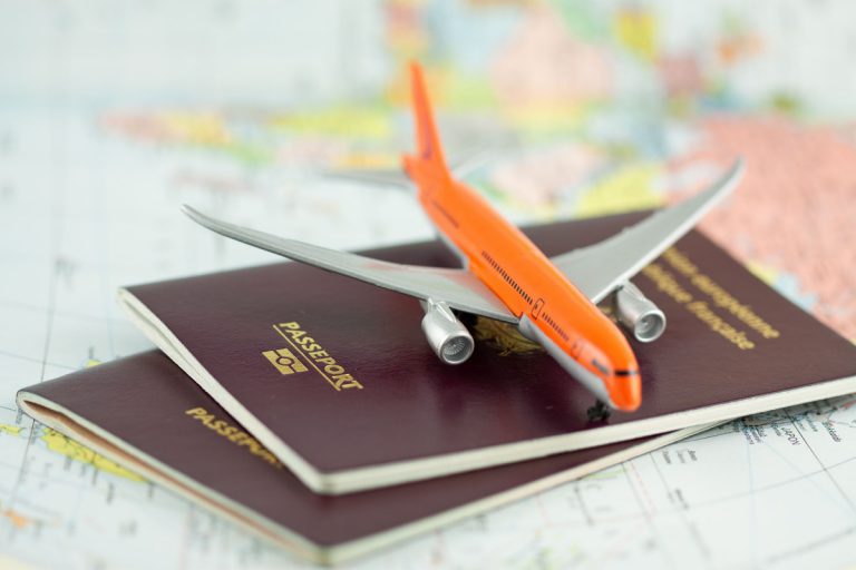 2 passeports et une maquette d'avion sur une carte de monde