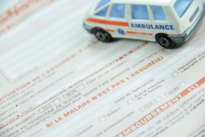 miniature voiture ambulance sur un formulaire d'assurance 