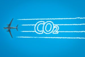 Avion en vol avec traînées blanches indiquant émission de CO2