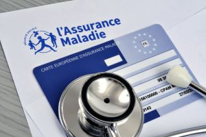 Stéthoscope posé sur une carte européenne assurance maladie et sur une feuille assurance