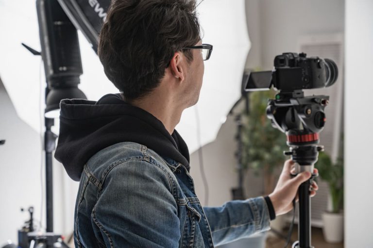 photographe professionnel tenant son appareil photo pour réaliser une prise de vue dans son studio