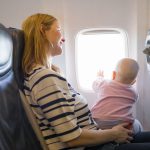 bébé jeune enfant dans avion sur les genoux de sa maman